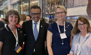 Four professionally dressed adults smile at the camera. Dr. Cynthia Baker appears on the far right.